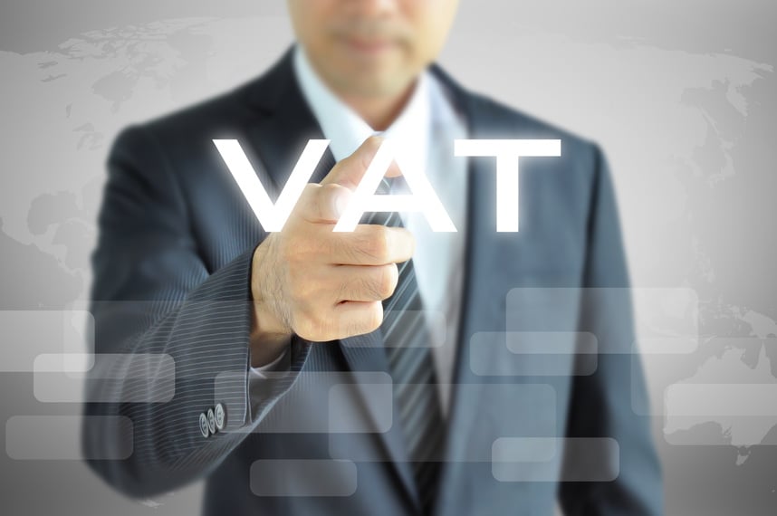 Businessman pointing to VAT (Value Added Tax) sign